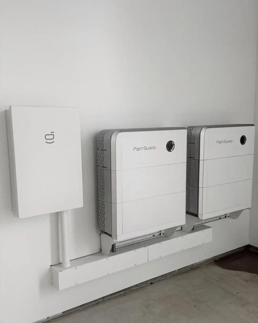 Two home battery units and a control box mounted on a wall